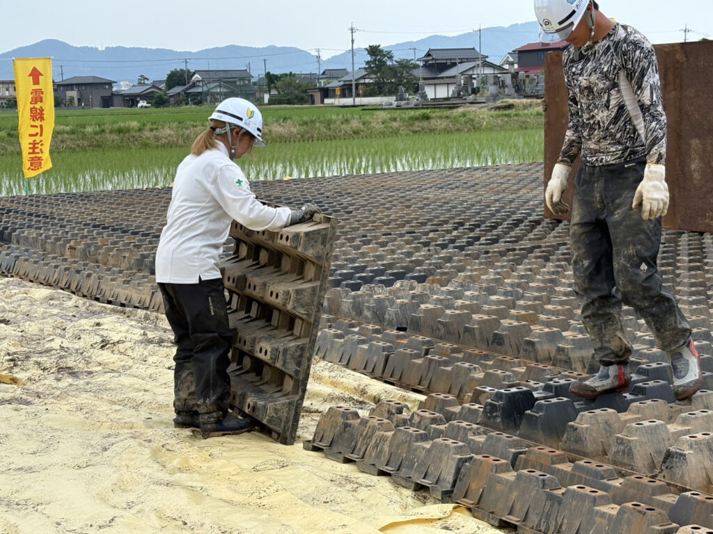 作業車両が通るための仮設道路を設置している小泉さんと先輩の様子